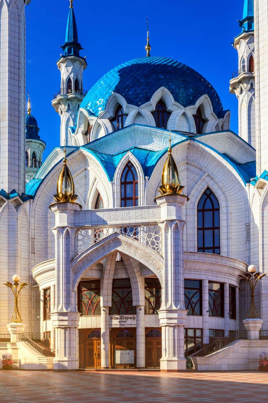 Façade bleue et blanche de la mosquée, avec ses minarets en arrière-plan