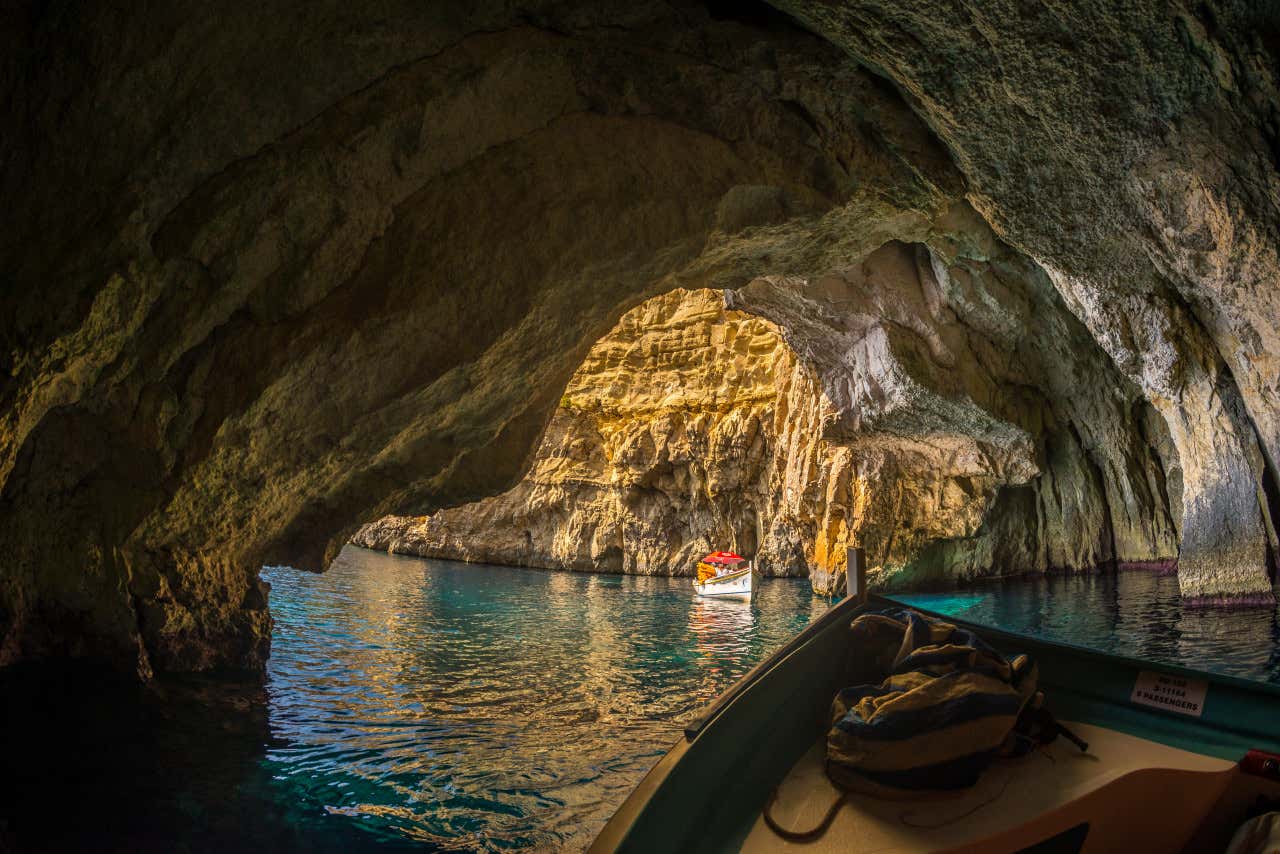 Detalle de una barca navegando por el interior de la Gruta Azul, en Malta