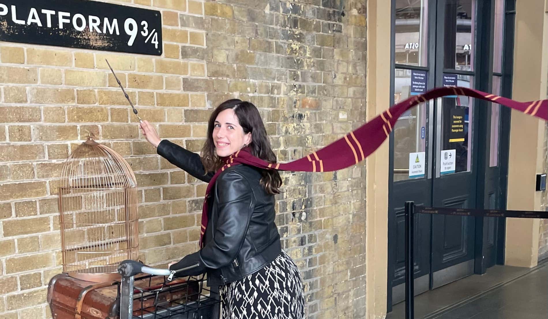 Rocío Molla posando en la entrada del andén 9 3/4 de Londres con un carrito que empieza a atravesar un muro de ladrillo