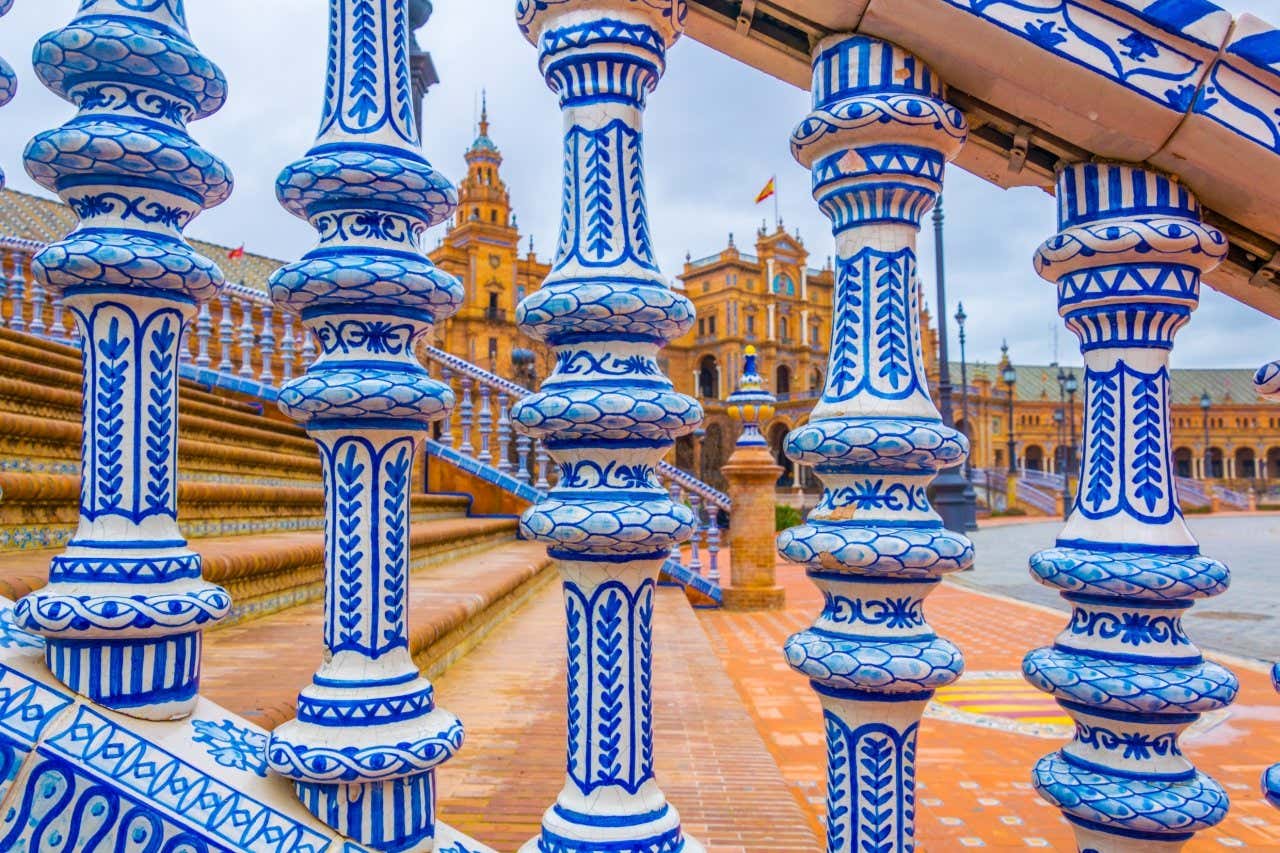 Detalhe em azul das escadas da Plaza de España feitas de azulejos de Triana, com um dos edifícios no fundo