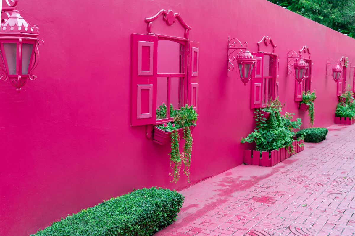 El Paseo de Doña Blanca de Puerto Plata una calle con adoquines, paredes farolas y ventanas de color rosa