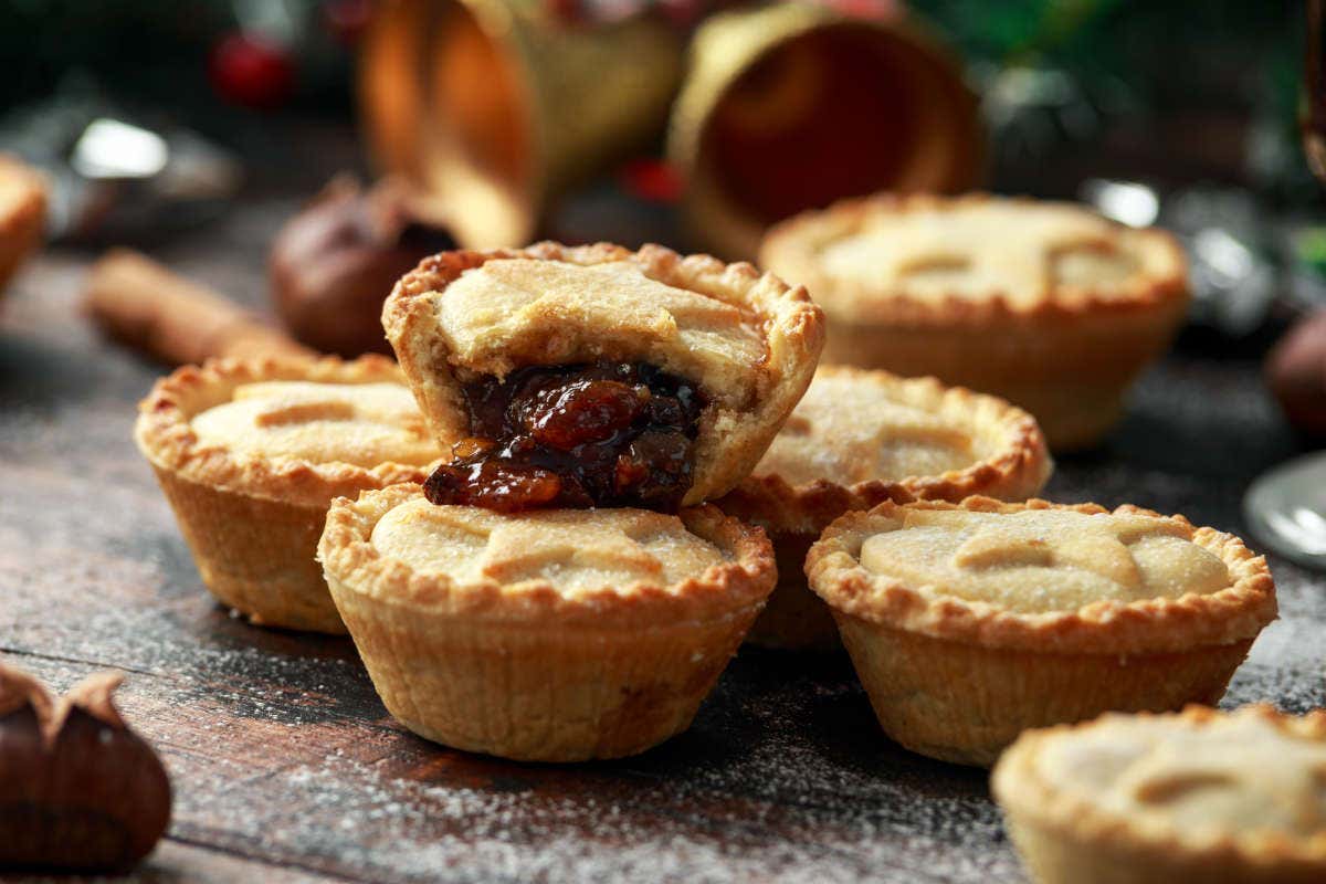 Pequeños Mince Pies enteros y uno de ellos abierto mostrando el relleno