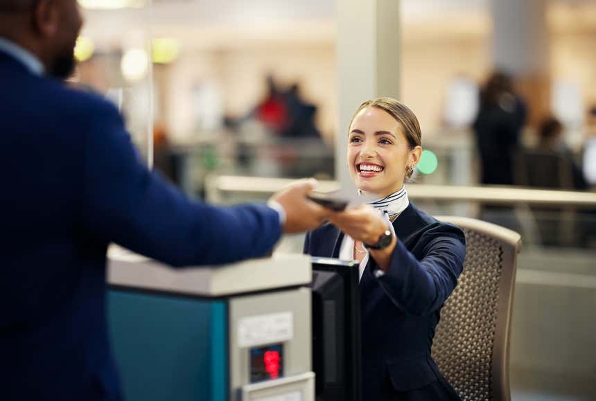 Employée de l'aéroport demandant ses papiers à un passager