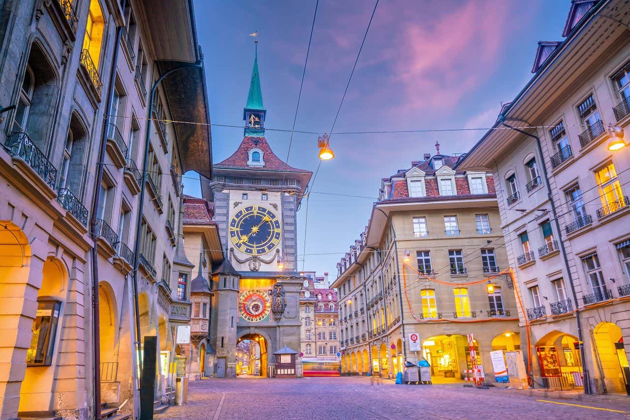 View of Bern's astronomical clock from an illuminated city street at dusk