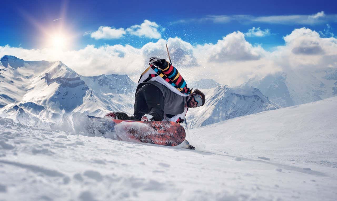 Homme glissant sur un snowboard dans les Alpes françaises avec des montagnes en arrière-plan par temps ensoleillé