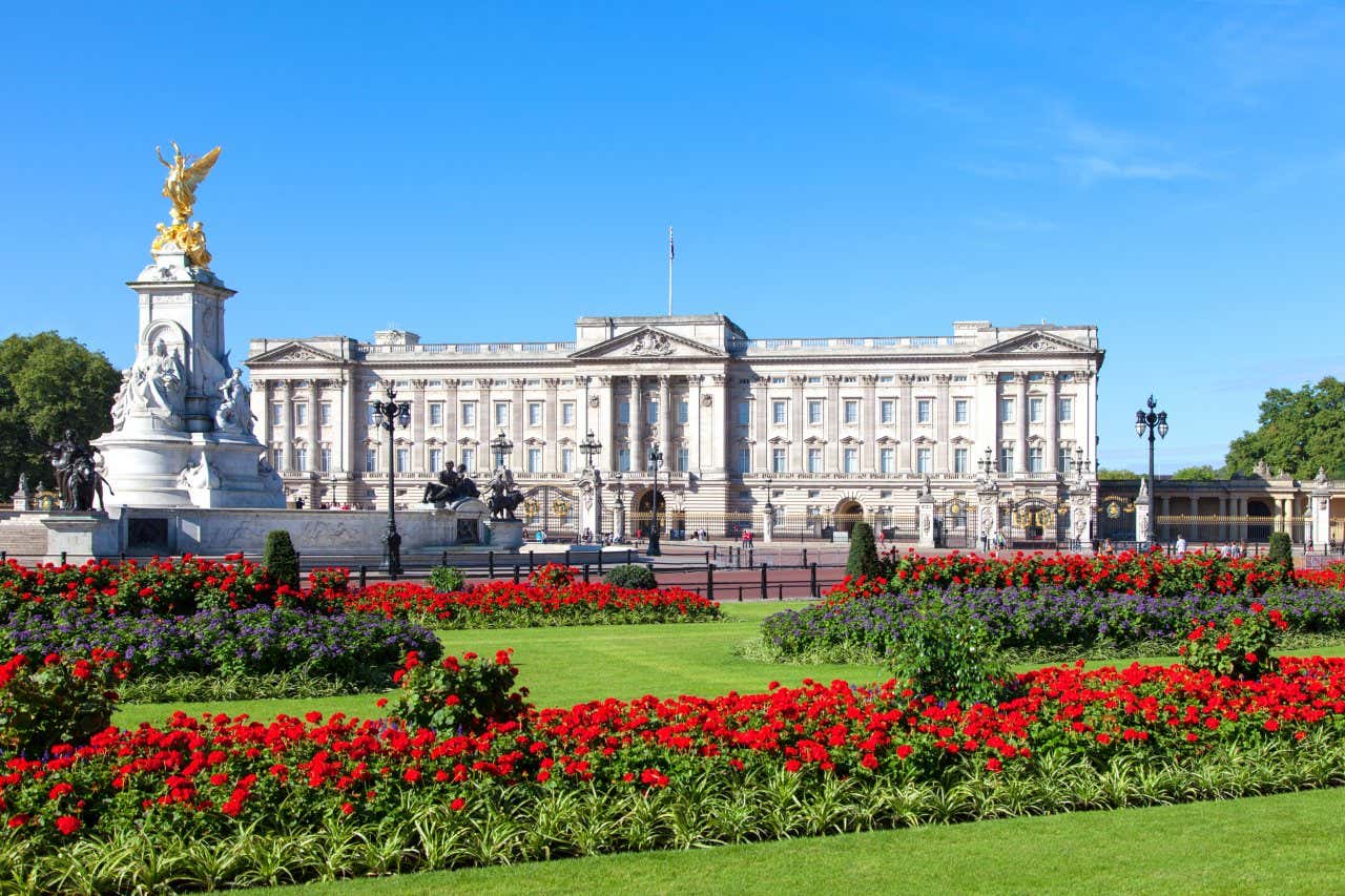 Panorama du palais de Buckingham avec les jardins royaux en face, remplis de fleurs rouges