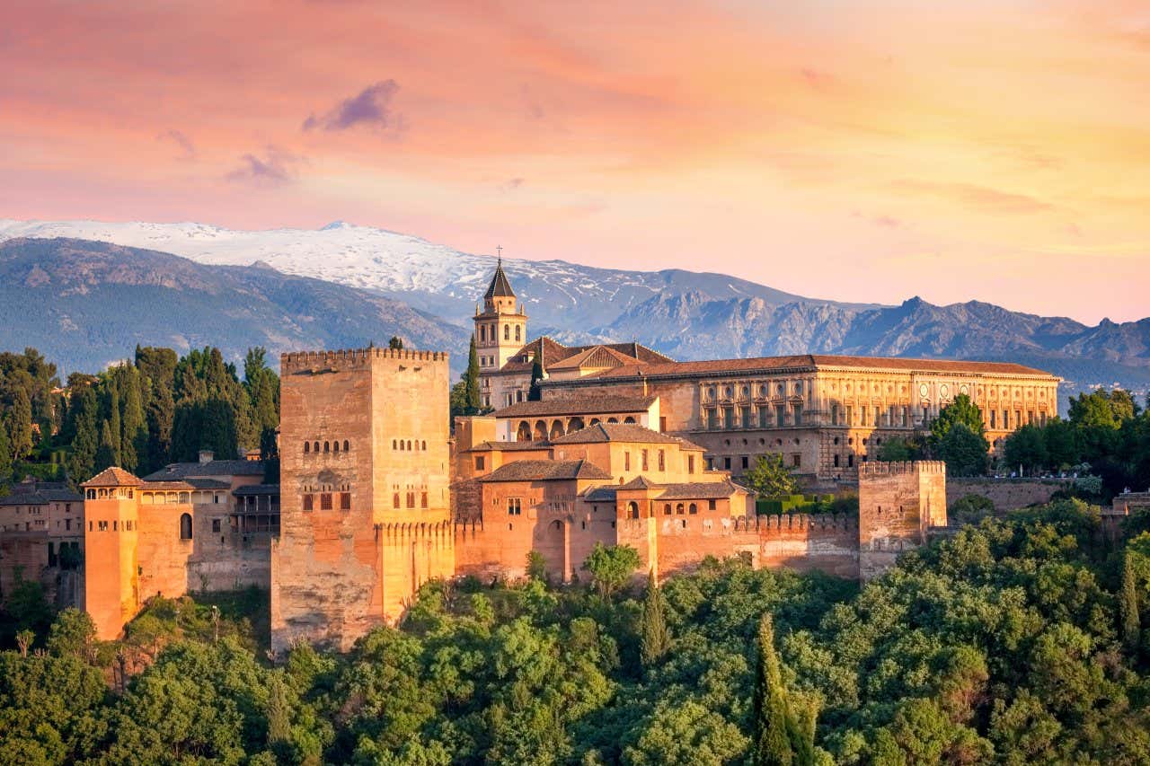 Vue panoramique sur l'ensemble des bâtiments de l'Alhambra avec la Sierra Nevada en fond, l'un des plus beaux palais du monde