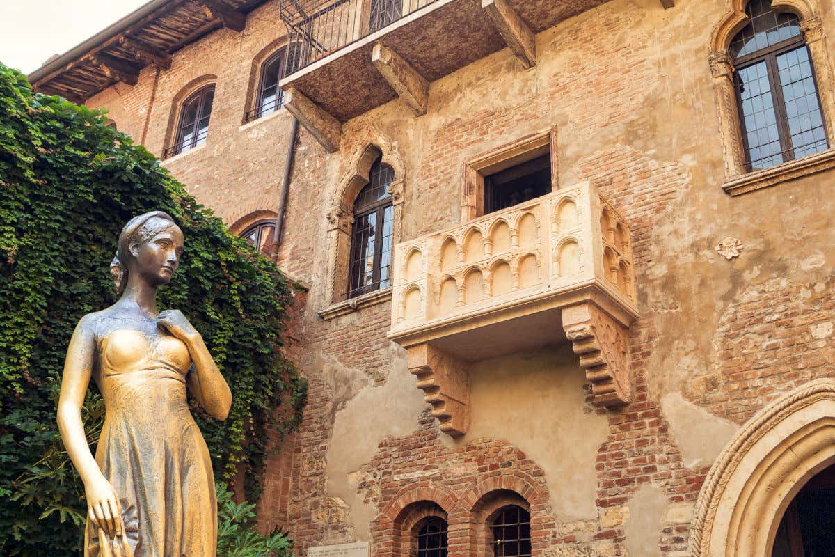 Escultura femenina frente a una enredadera en el patio de la casa de Romeo y Julieta, en Verona