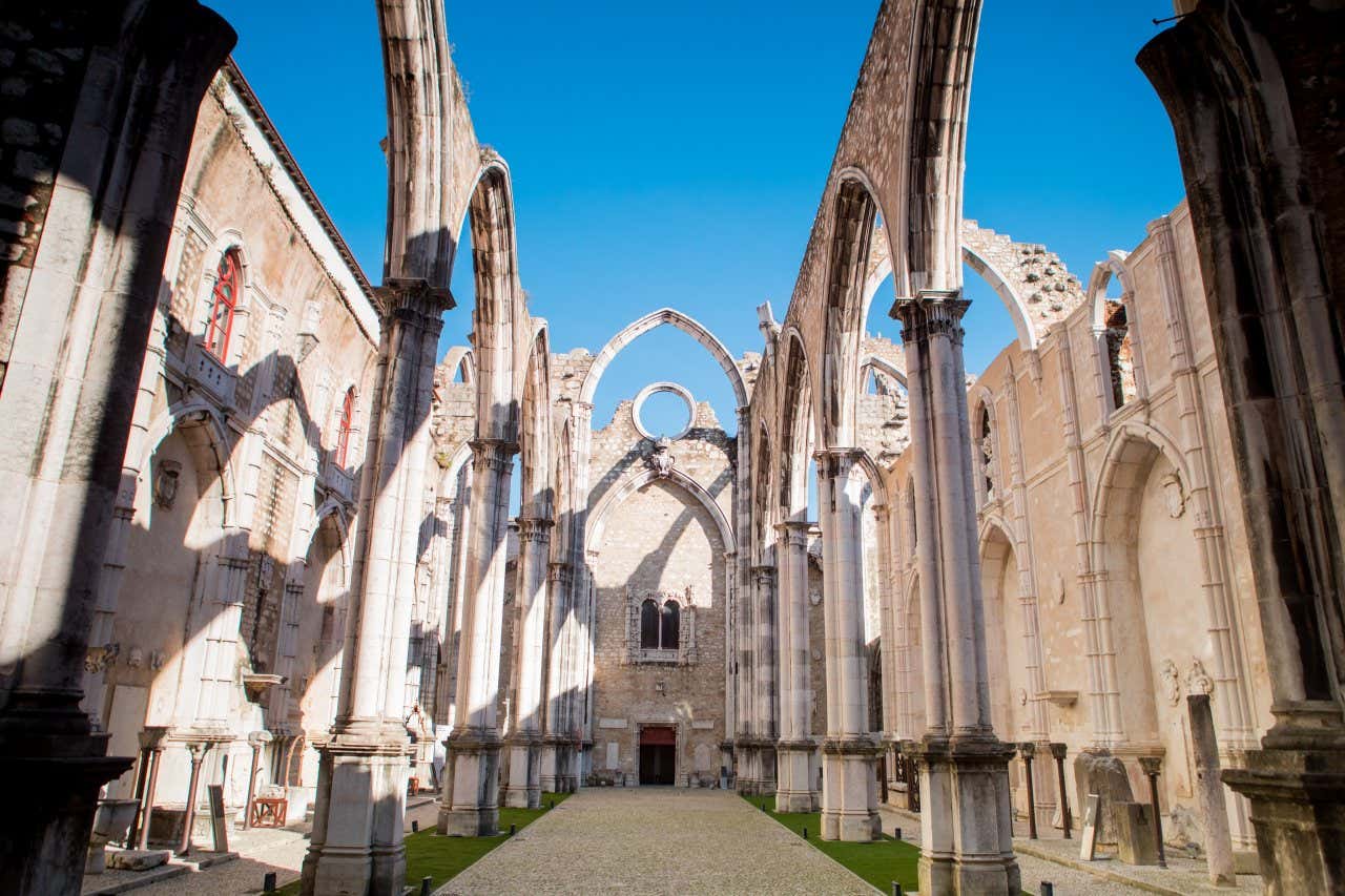 Remains of the ruins of the Carmo Convent under a blue sky.