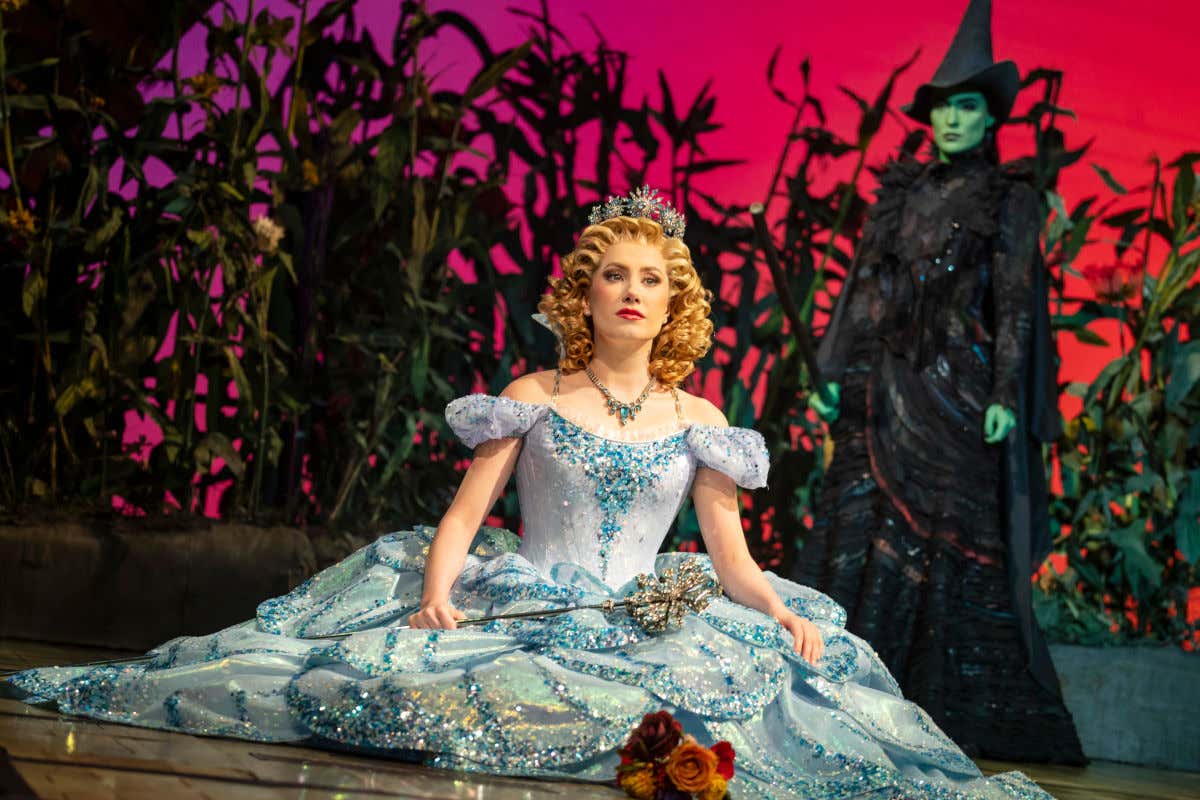 Une sorcière à la peau verte vêtue d'un costume noir regarde une princesse pendant la comédie musicale Wicked à New York