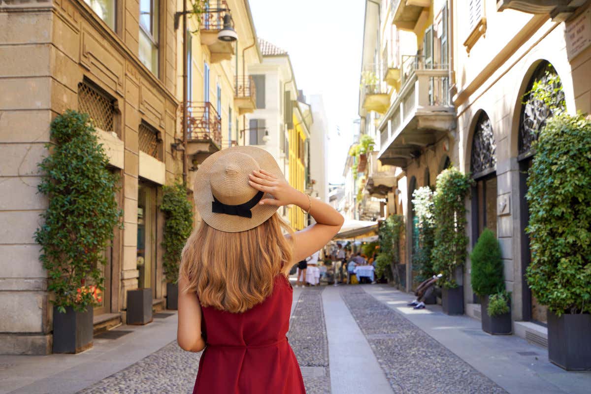 Una donna di spalle con un cappello di paglia in testa