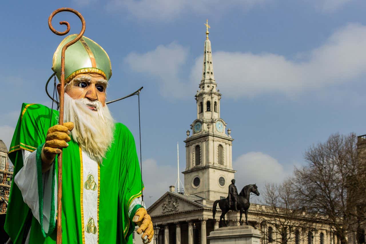 Um carro alegórico verde e branco do Dia de São Patrício passando pela Praça de Trafalgar.