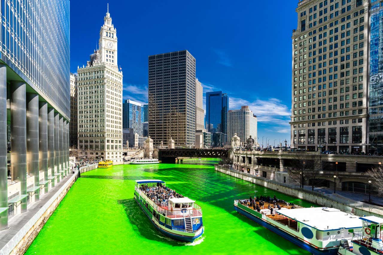 Vários barcos navegando pelo rio Chicago, que foi tingido de verde para o Dia de São Patrício.