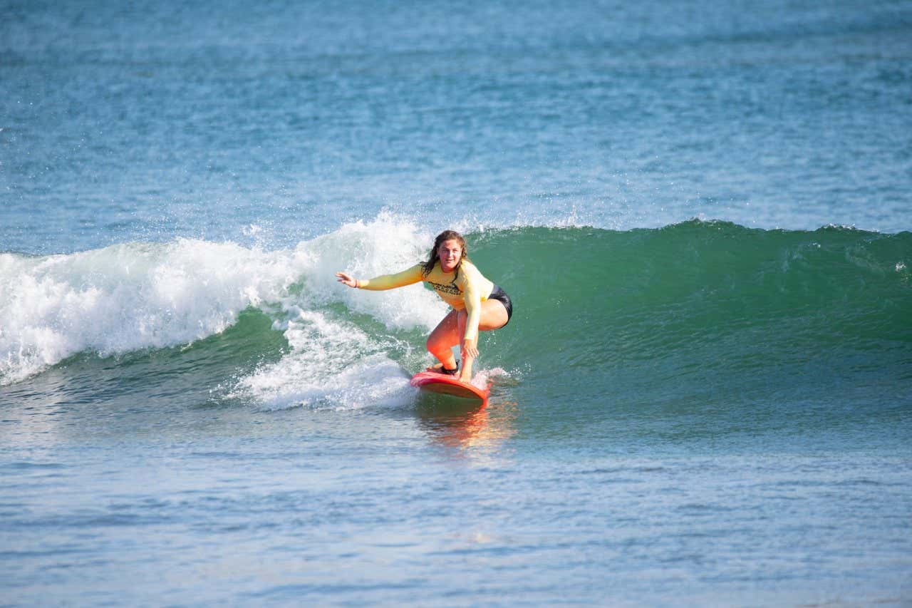 Uma mulher surfando na Playa de Pedasi, uma das melhores praias para praticar esportes aquáticos