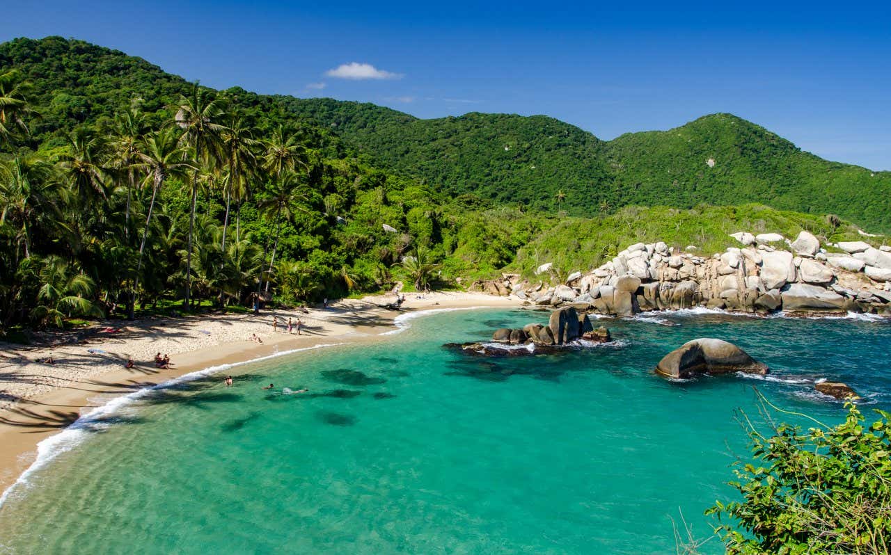 Praia caribenha do Parque Tayrona com águas turquesa e rodeada por vegetação