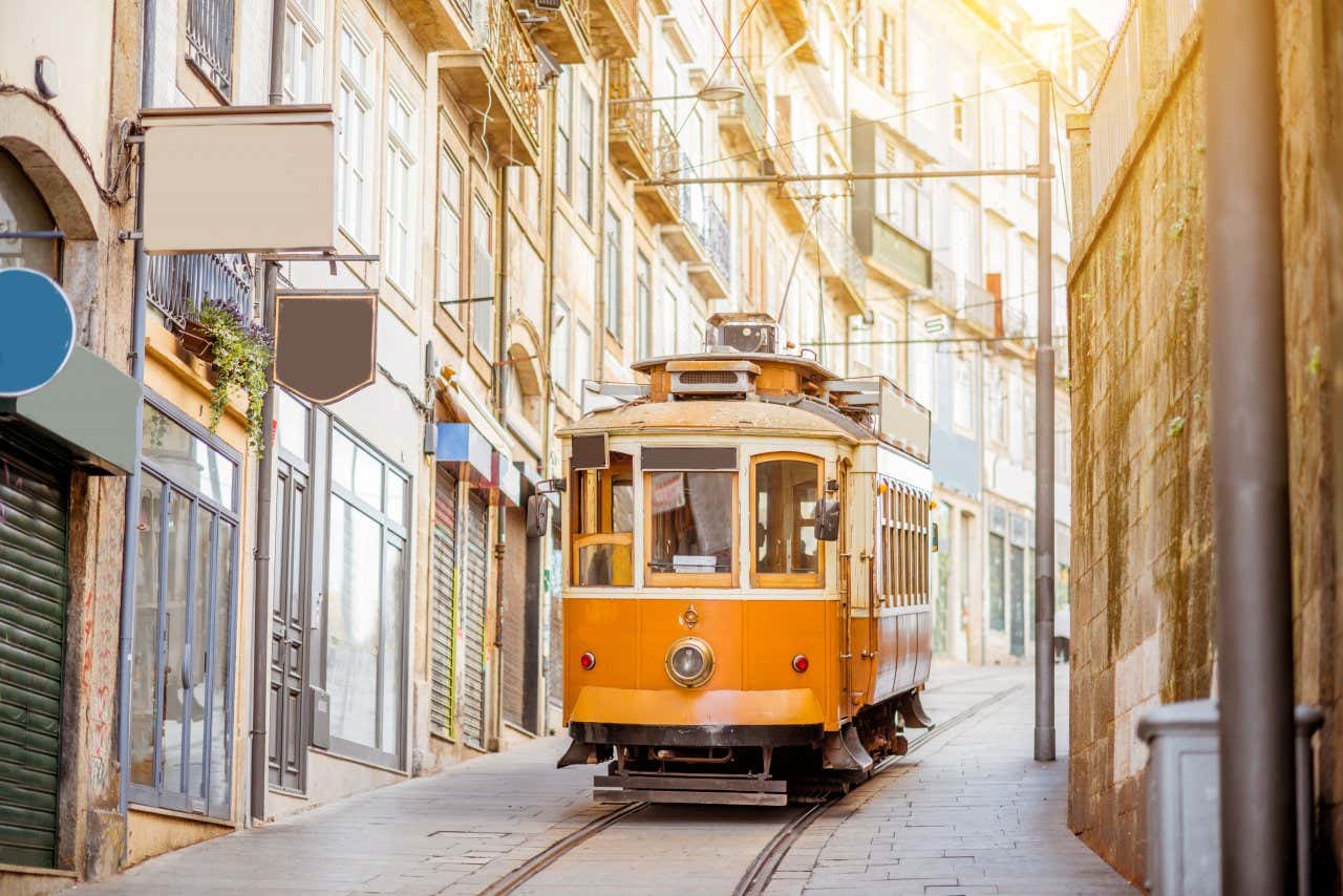 Un antiguo tranvía amarillo por una calle empinada de Oporto