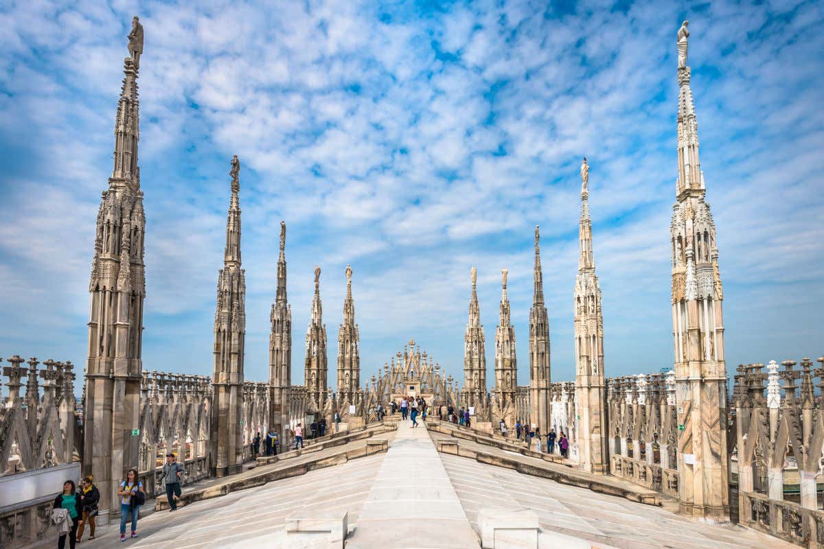 Diversi turisti camminano sulle terrazze del duomo di Milano