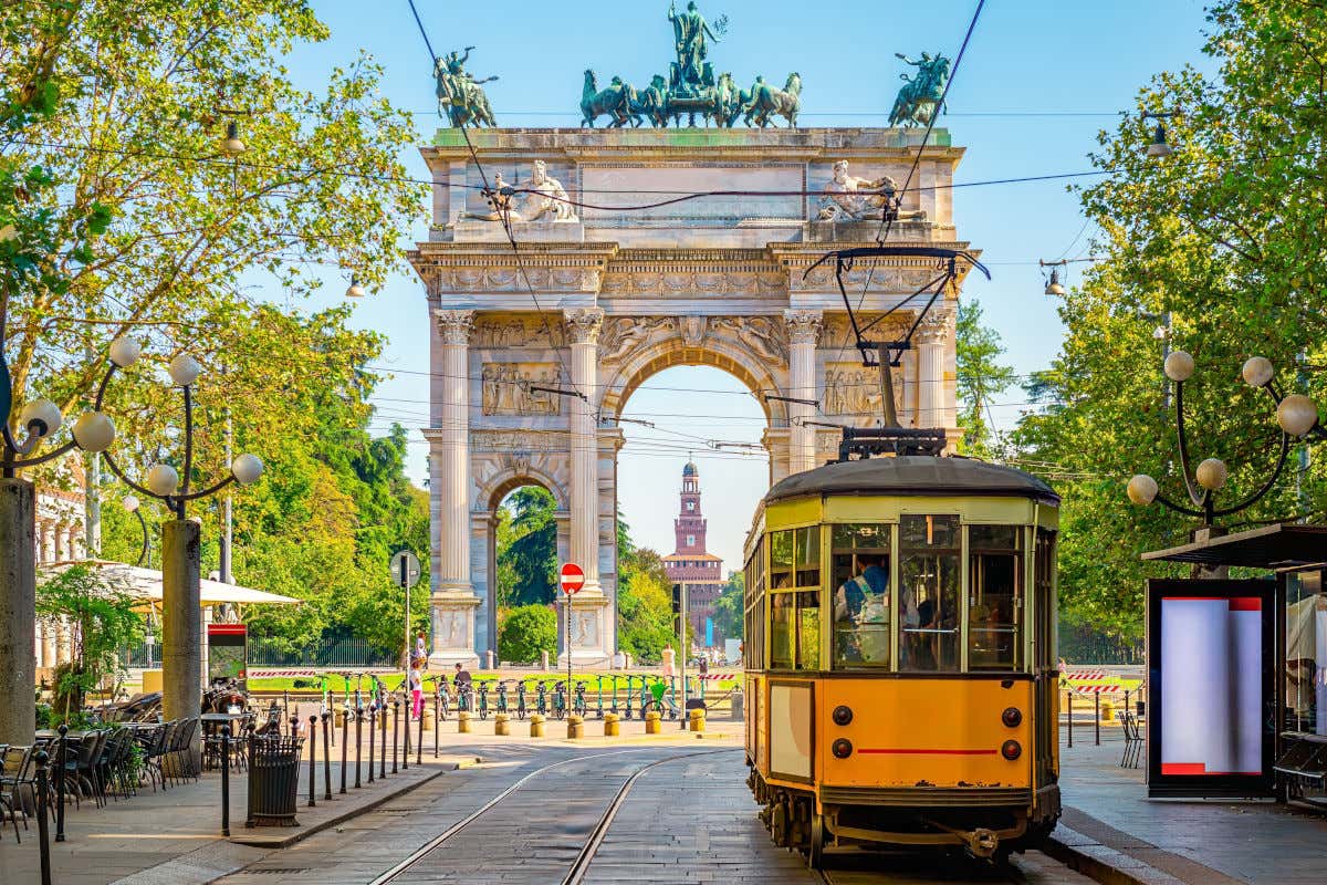 Un piccolo tram davanti a un arco monumentale