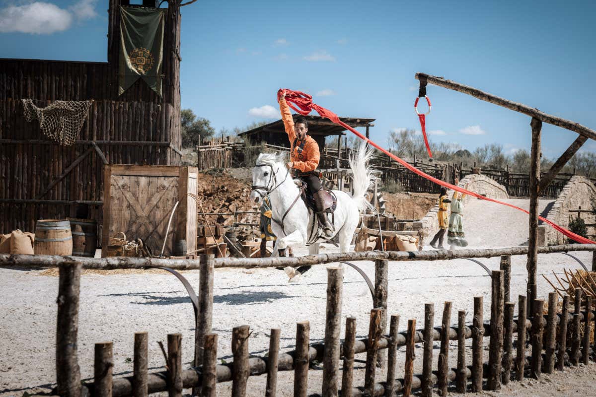 Un cavaliere su un cavallo bianco nella ricostruzione di un villaggio medievale a Puy du Fou, Toledo