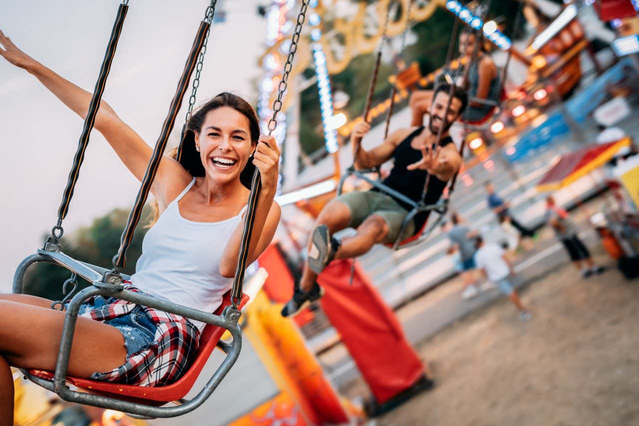 Tres personas subidas en un columpio en un parque de atracciones