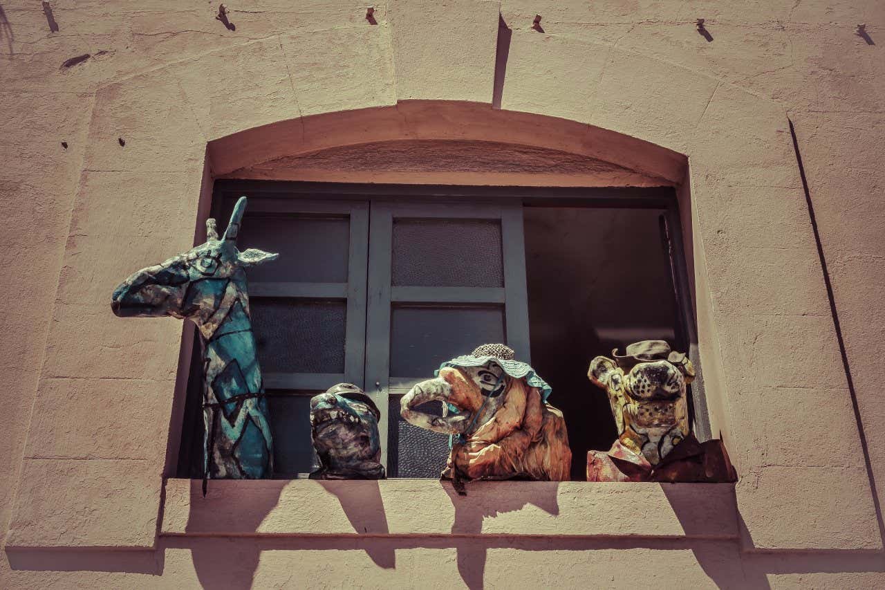 Four animal puppets sticking out of a window