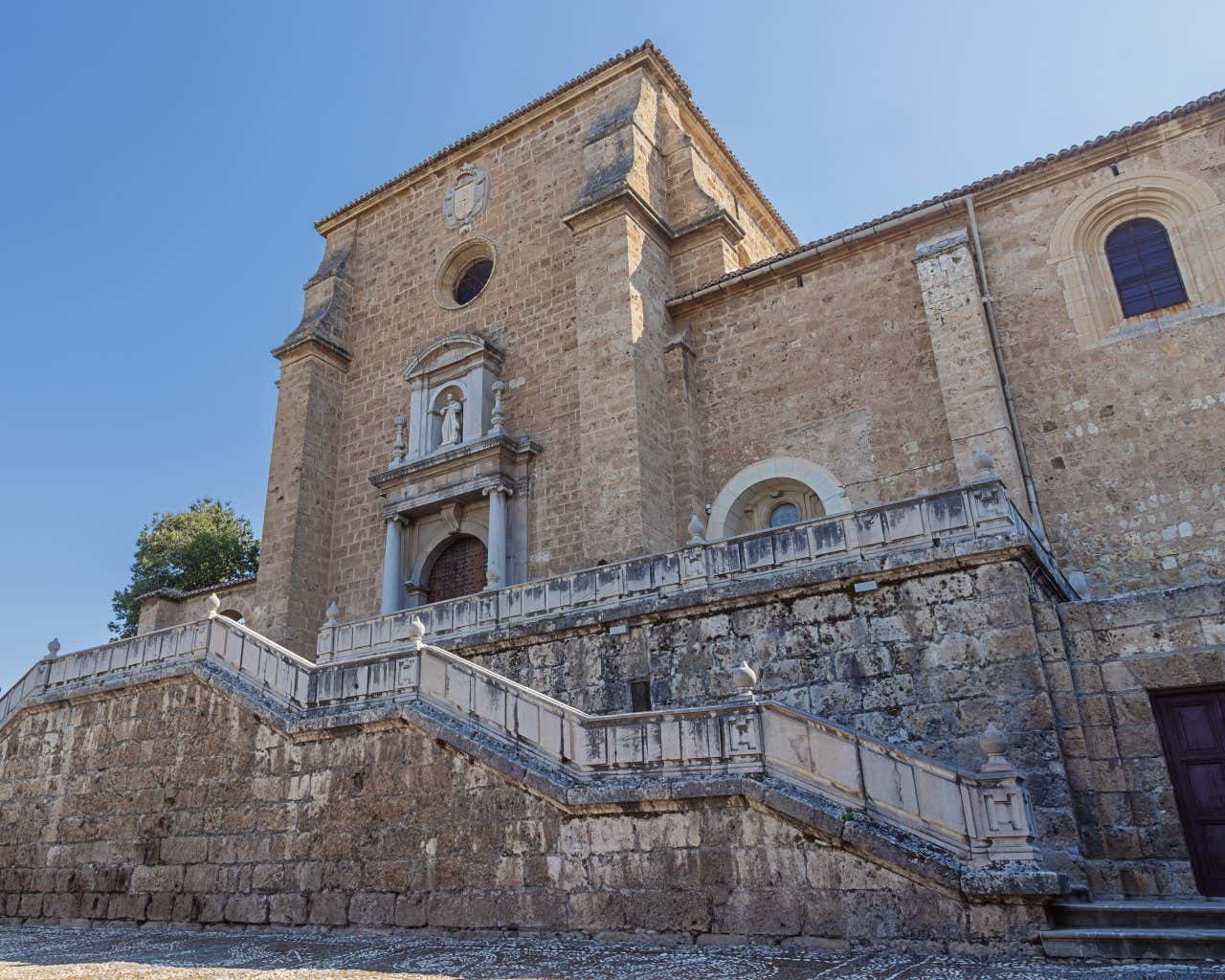 The entrance to the Cartuja Monastery in Granada, with a clear blue sky in the background.