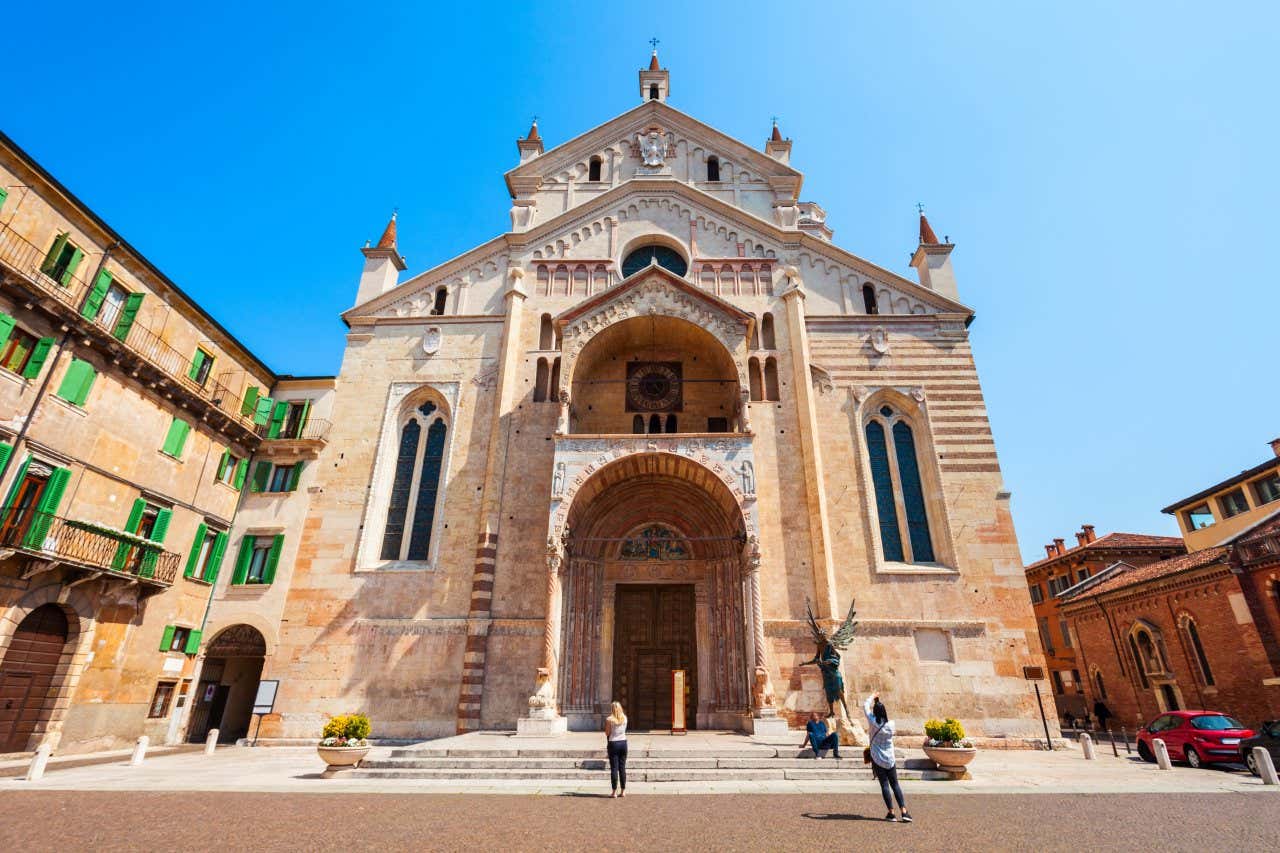 People standing outside Verona Cathedral taking pictures.