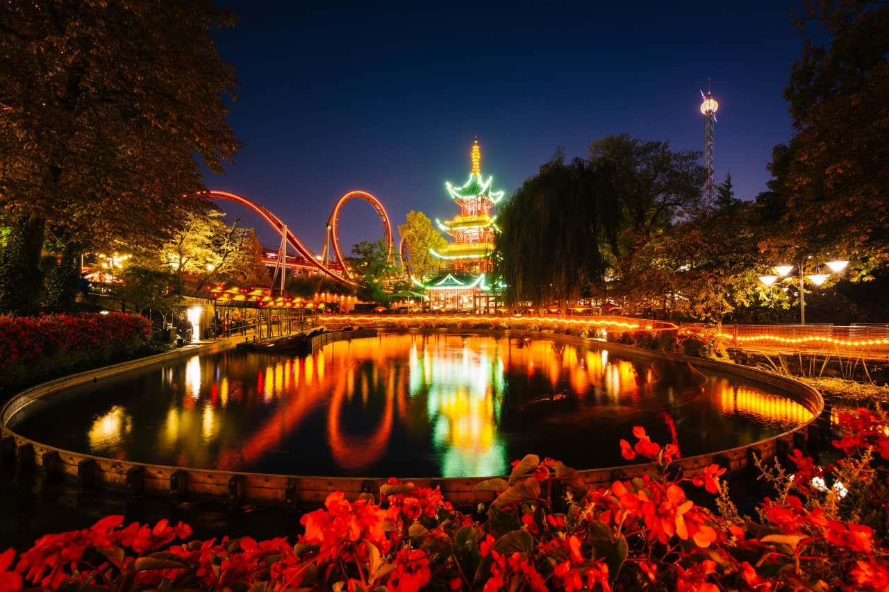 Attractions in Tivoli Gardens lit up at night.