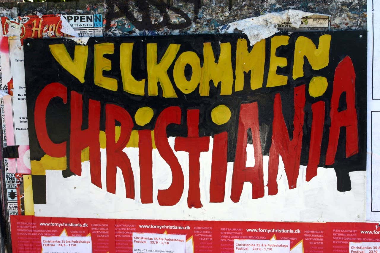 Poster " Benvenuti a Christiana" appeso a un muro del distretto di Christiana