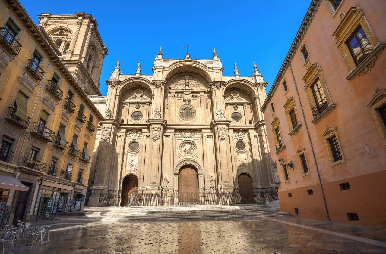 The entrance to the Granada Cathedral as seen from ground level, with a clear blue sky in the background.