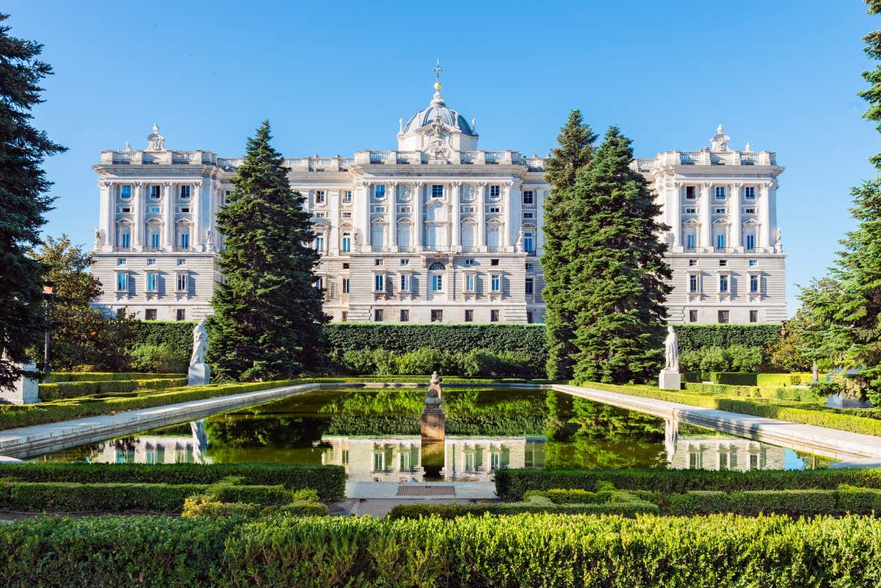 Vue sur l'une des façades du Palais royal de Madrid, avec des jardins en premier plan