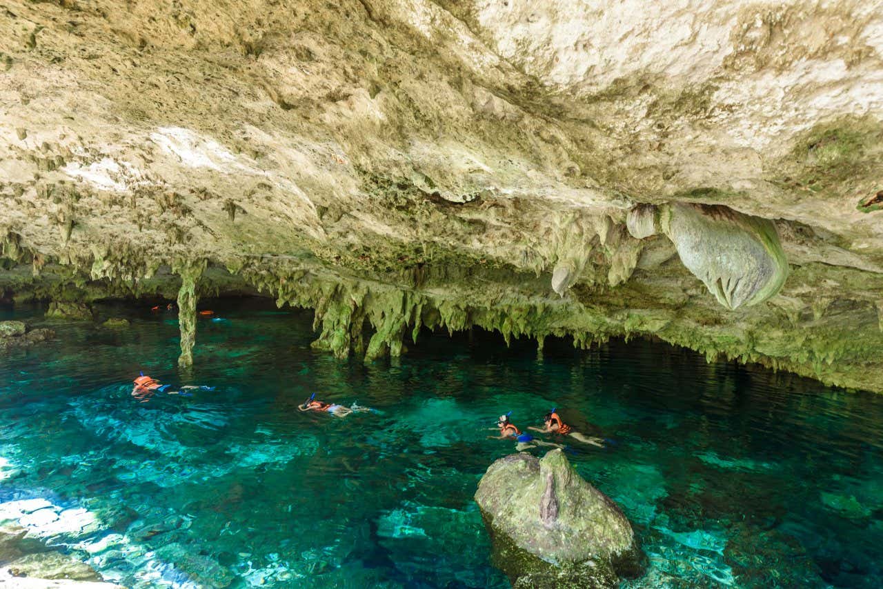 Alcuni visitatori fanno snoreling nelle acqua trasparenti di una piscina naturale