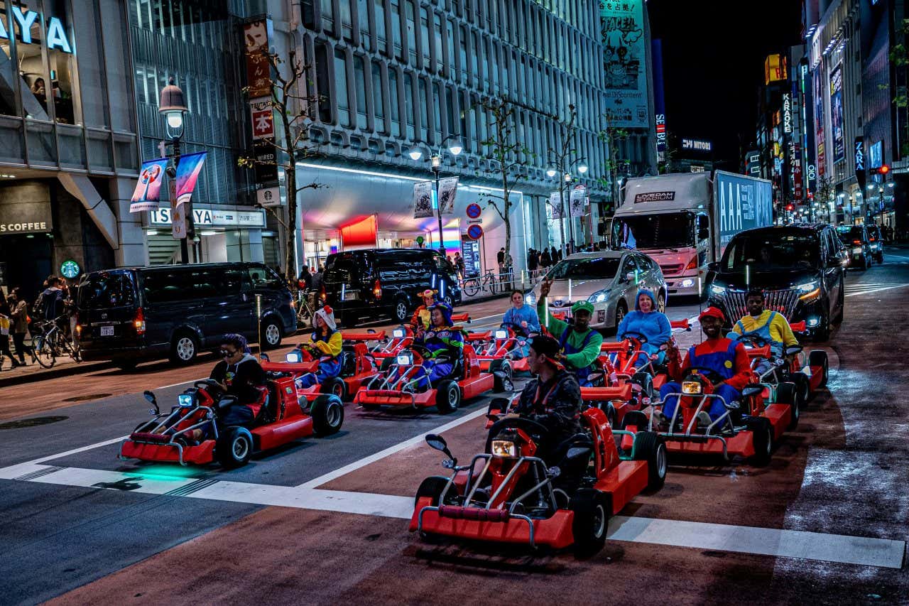 Alcuni partecipanti alla corsa in kart per la strade di Tokyo, a bordo dei loro kart e vestiti da personaggi di Super Mario e di altri videogiochi o anime