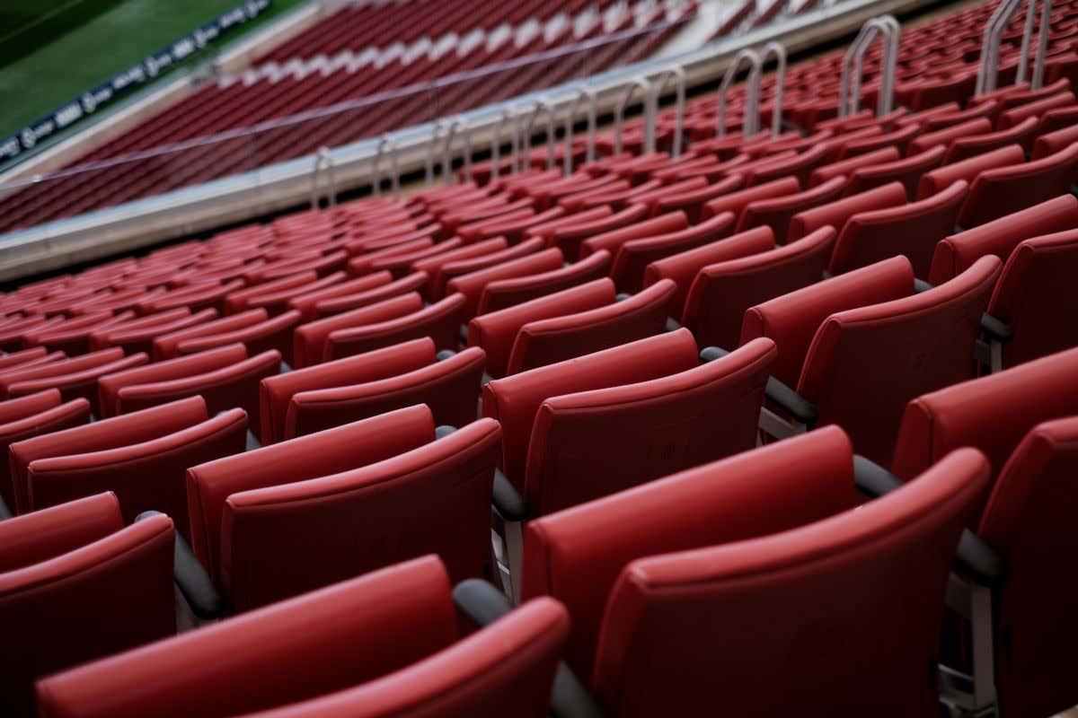 Asientos rojos con vistas al césped de un estadio de fútbol