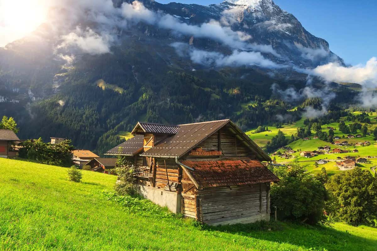 Una casa típica alpina a los pies de unas montañas