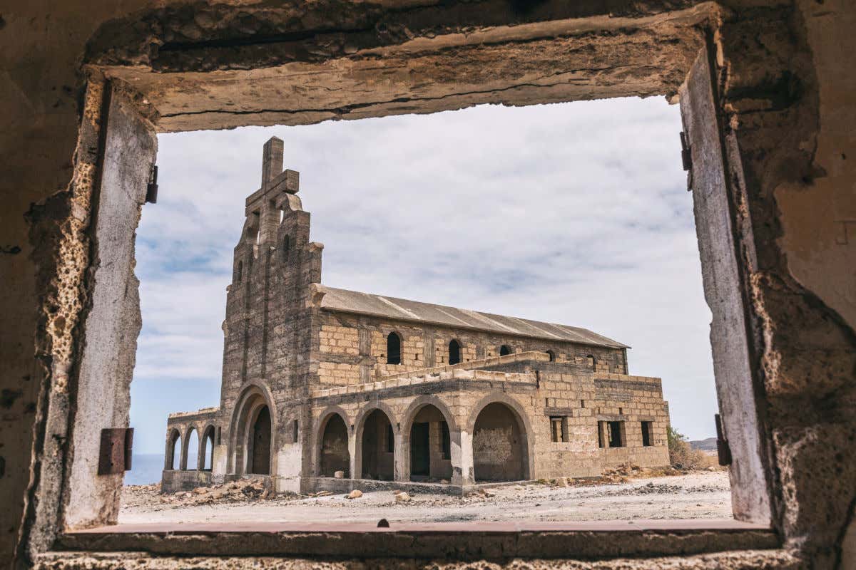 Una iglesia de piedra inacabada en mitad de un terreno abandonado