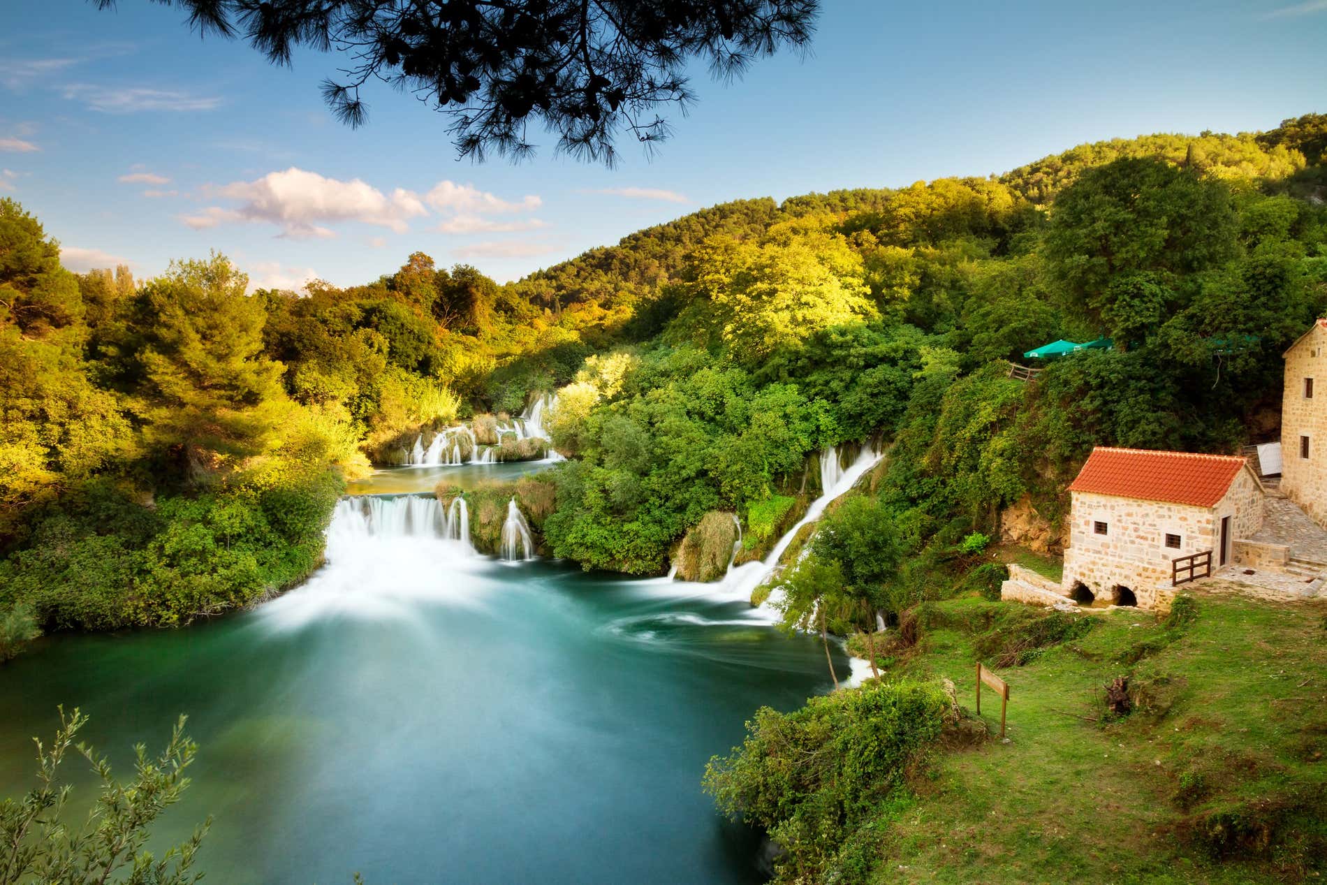 Cascate si tuffano nelle piscine naturali del Parco Nazionale Krka circondate da folti alberi, nella lista di cosa vedere in Croazia