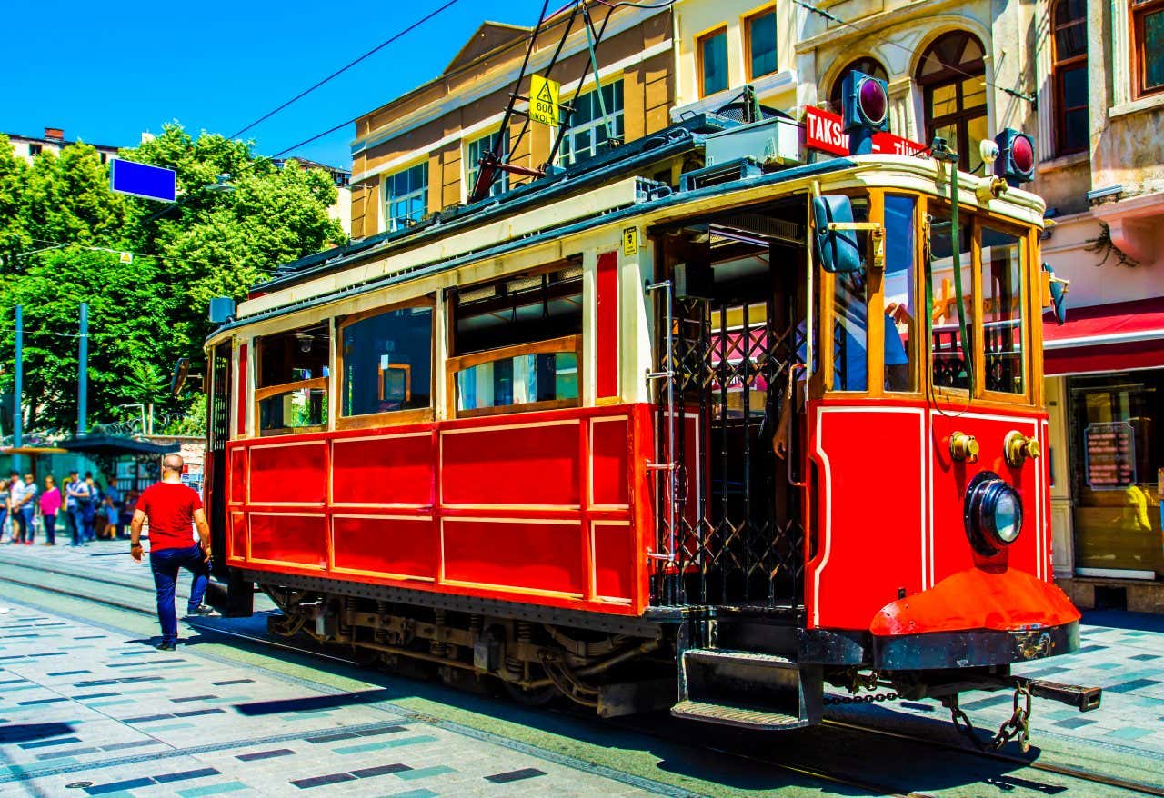 Gros plan sur un vieux funiculaire rouge au milieu d'une avenue