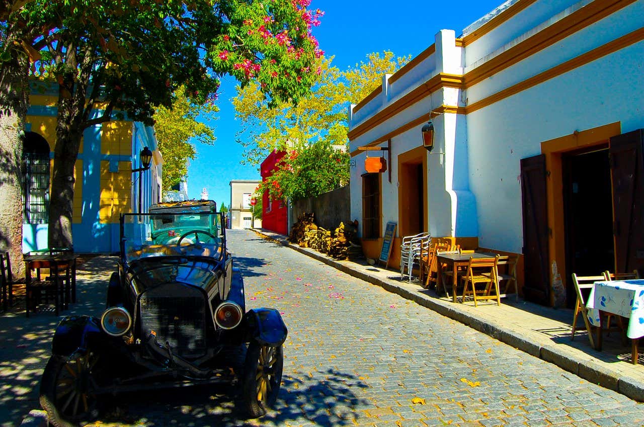 Une voiture ancienne dans une rue pavée et colorée de Colonia del Sacramento