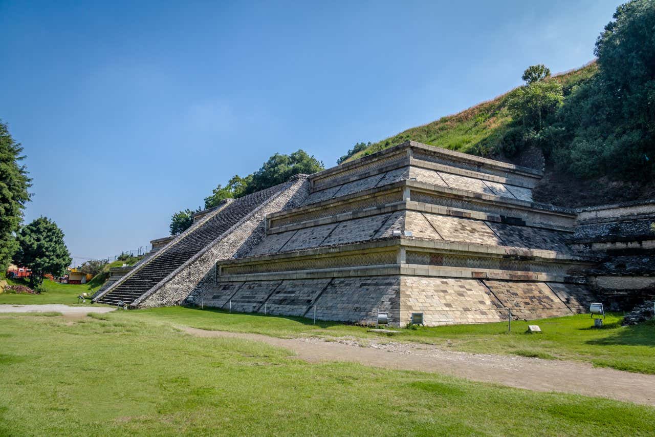 The Great Pyramid at Cholula seen on a sunny day with grass around it.