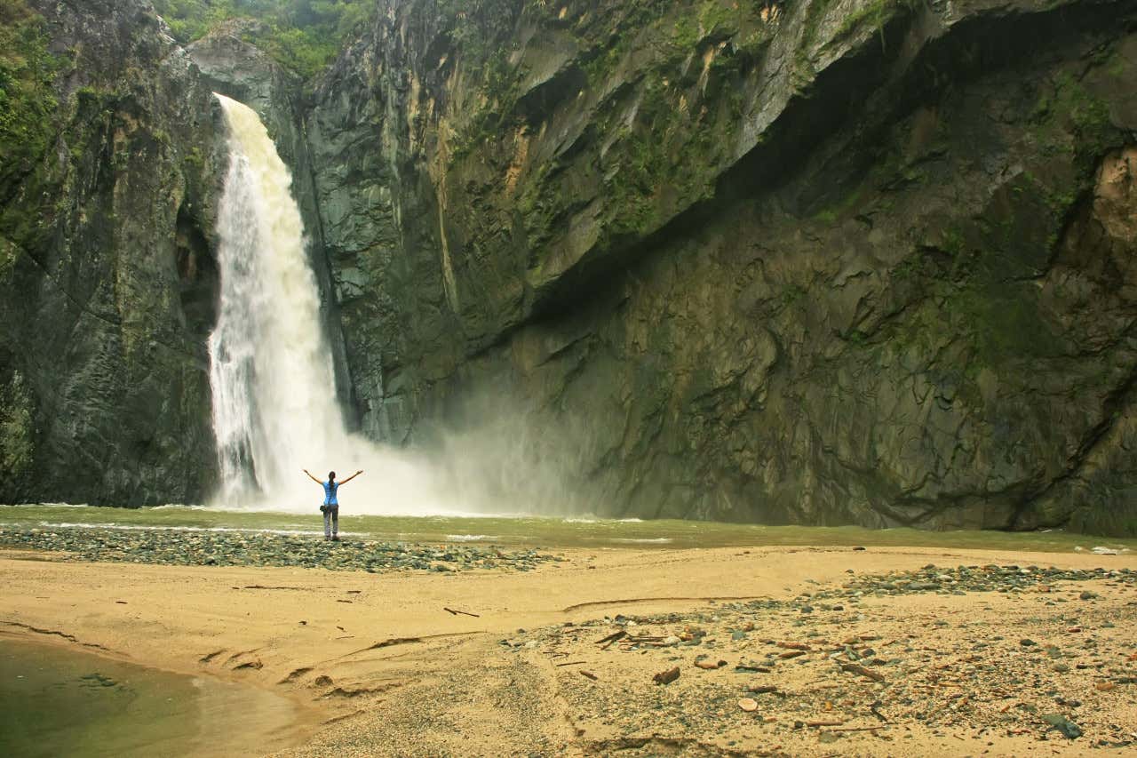 Una mujer presenciando la caída de agua del salto Jimenoa uno