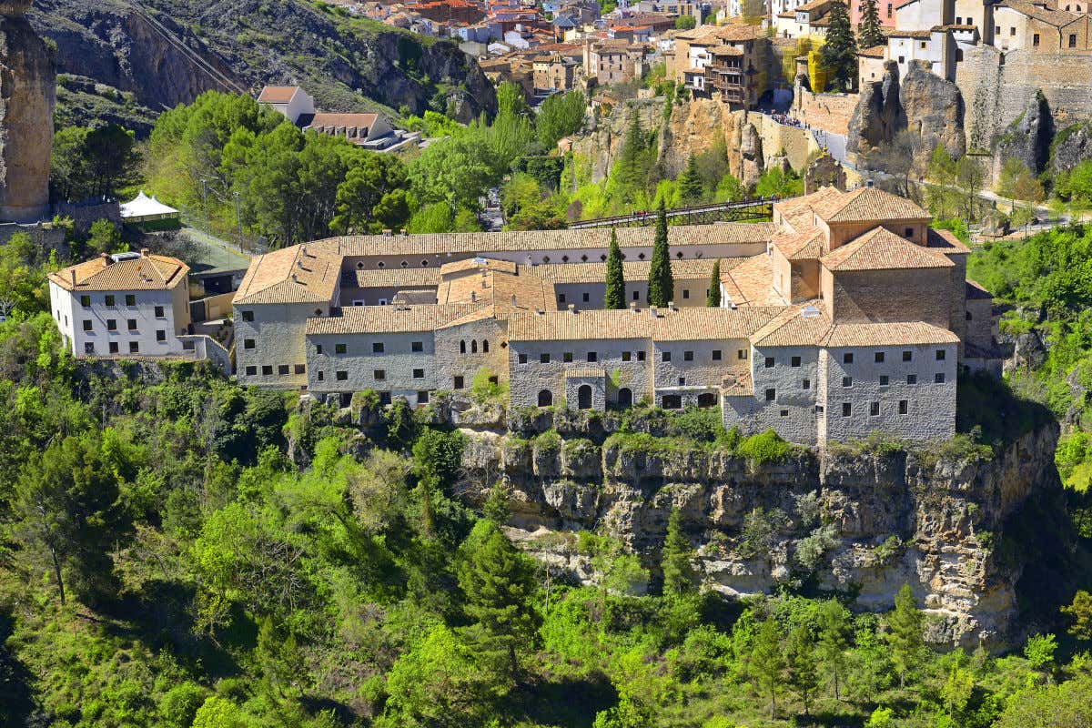 Vista aérea del convento de San Pablo en lo alto de un acantilado rodeado por vegetación y cerca de las Casas Colgadas de Cuenca