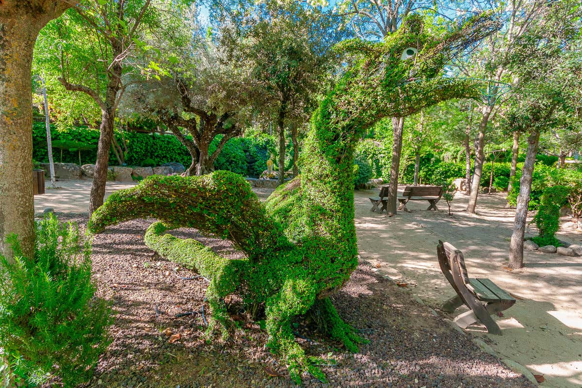 Escultura de un dragón hecha con hojas y césped en un parque conocido como El Bosque Encantado de Madrid