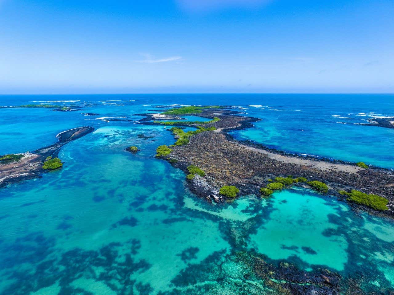 Aerial view of Isabel Island surrounded by turquoise water full of corals