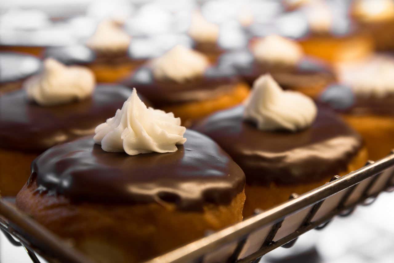 Ciambelle con glassa al cioccolato e ciuffo di panna in cima