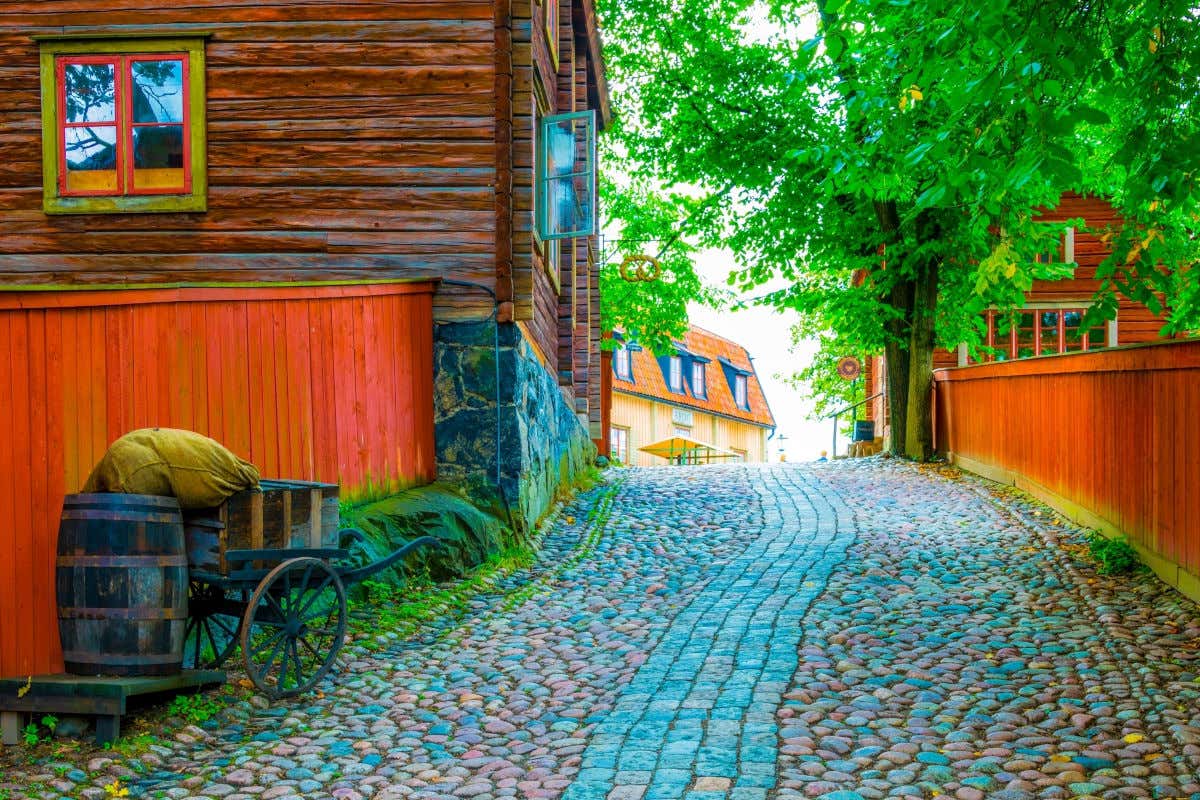 Una strada acciottolata con case di legno colorate presso il museo all'aperto Skansen di Stoccolma