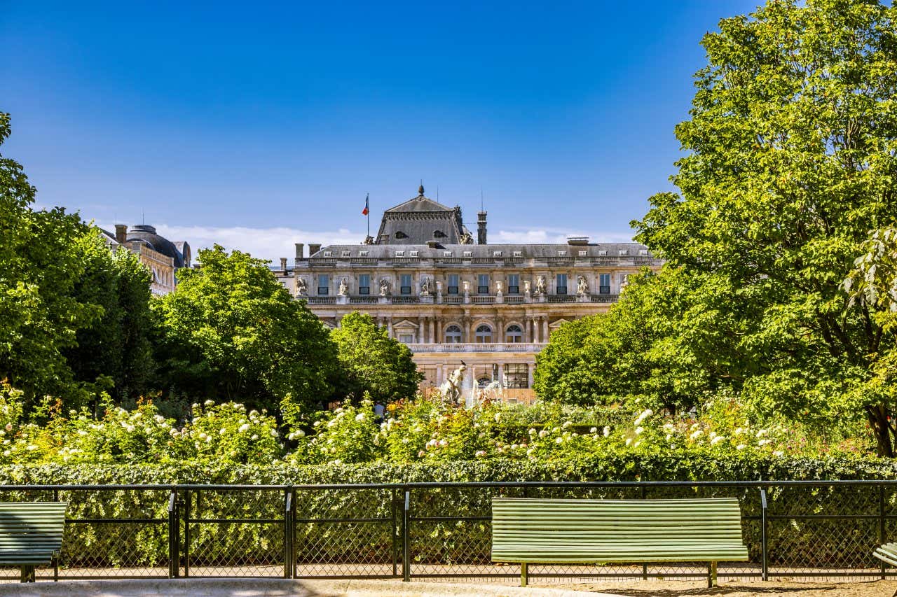 Una panchina all'interno di un giardino decorato con piante, fiori e giochi d'acqua nel centro di Parigi