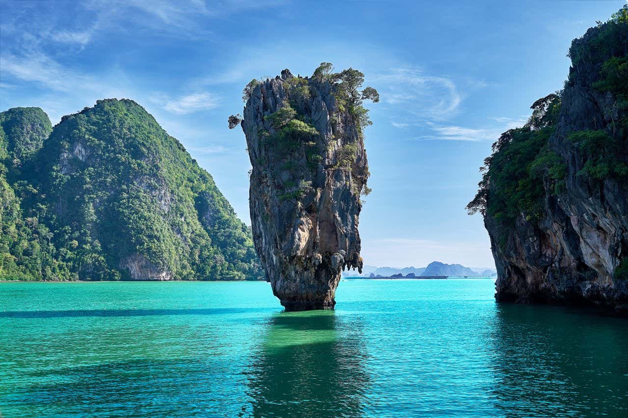 Uno scoglio piuttosto alto emerge dal mare turchese al largo della costa di Koh Tapu in Tailandia