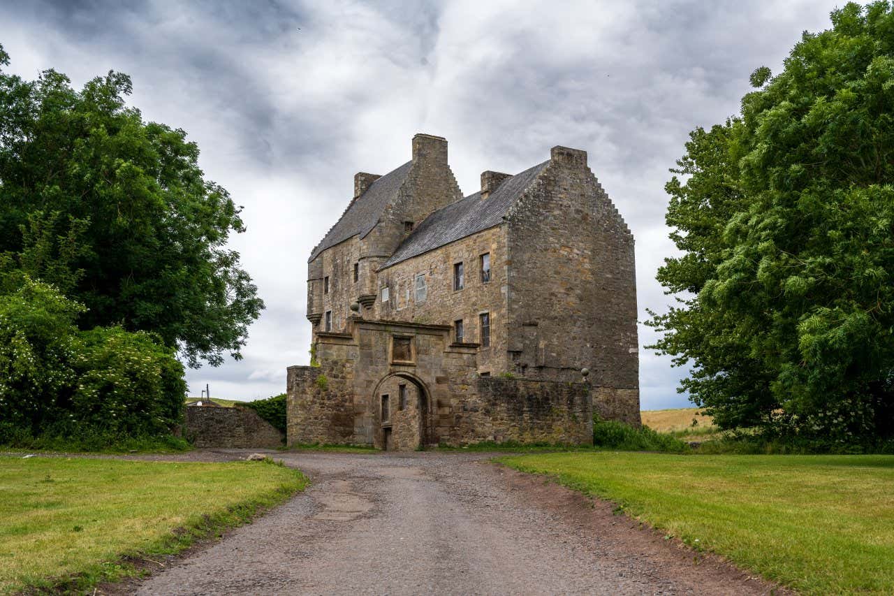 I resti di un'antico castello in pietra immerso nella campagna in una giornata nuvolosa