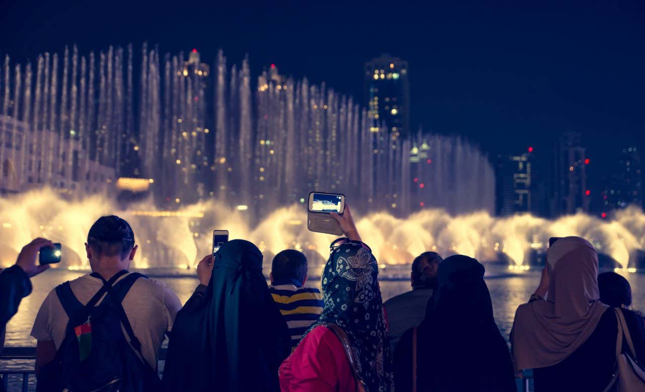 Visitors taking photos of the Bellagio fountains at night